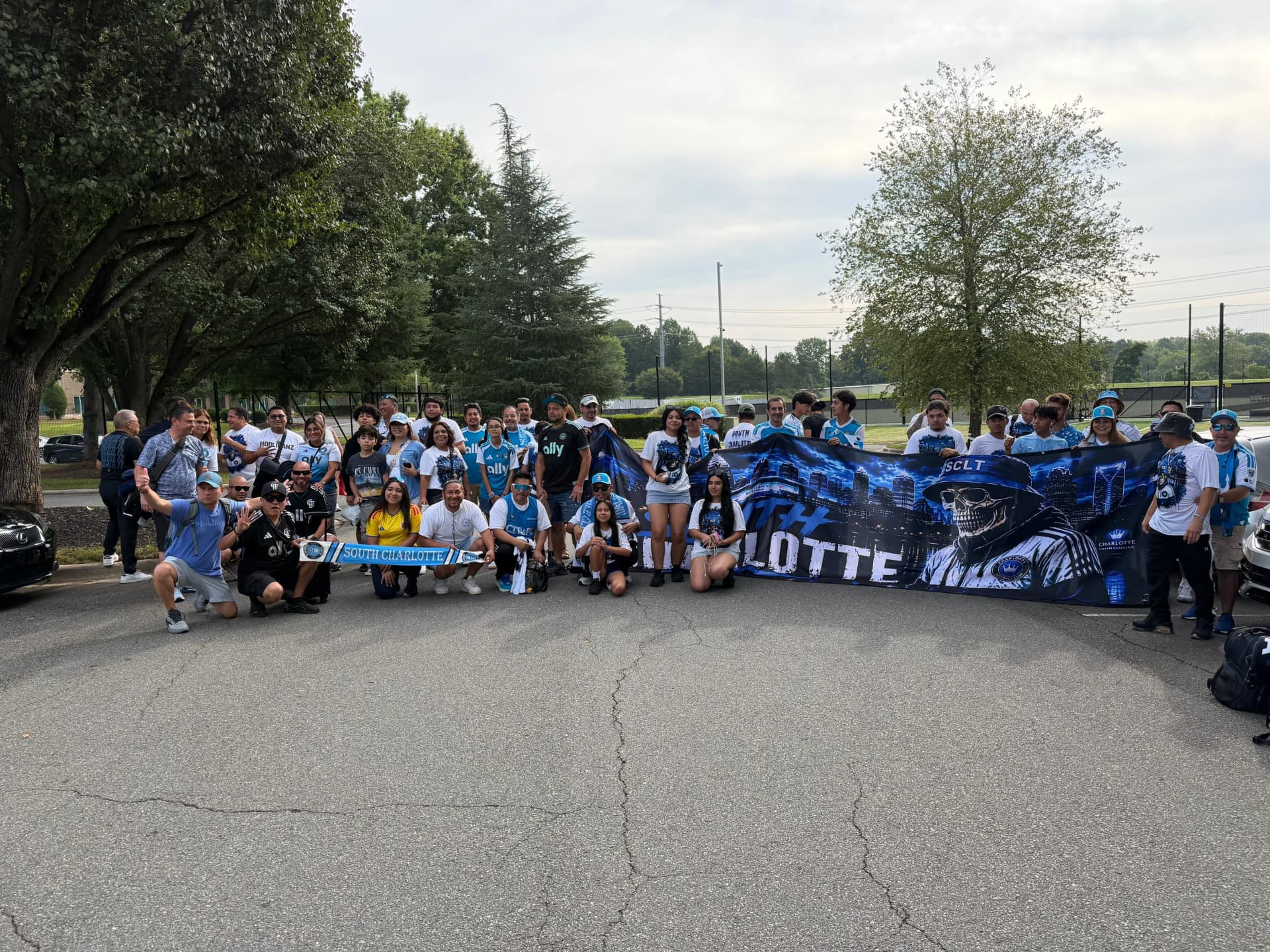 The full traveling group of Charlotte FC supporters, including NC United FC members, gathered behind a large South Charlotte banner