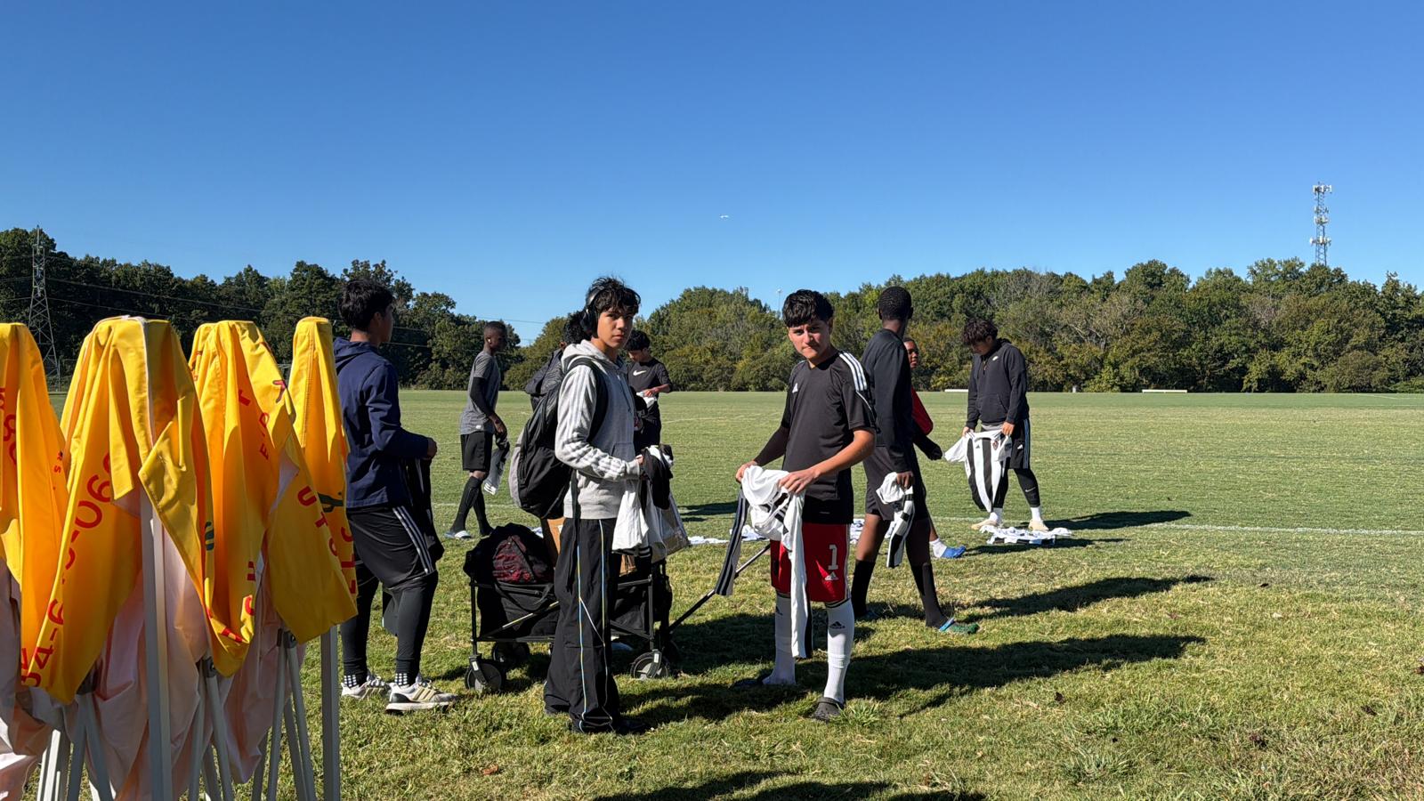 U17 Academy players preparing their kits on the sideline before a match.