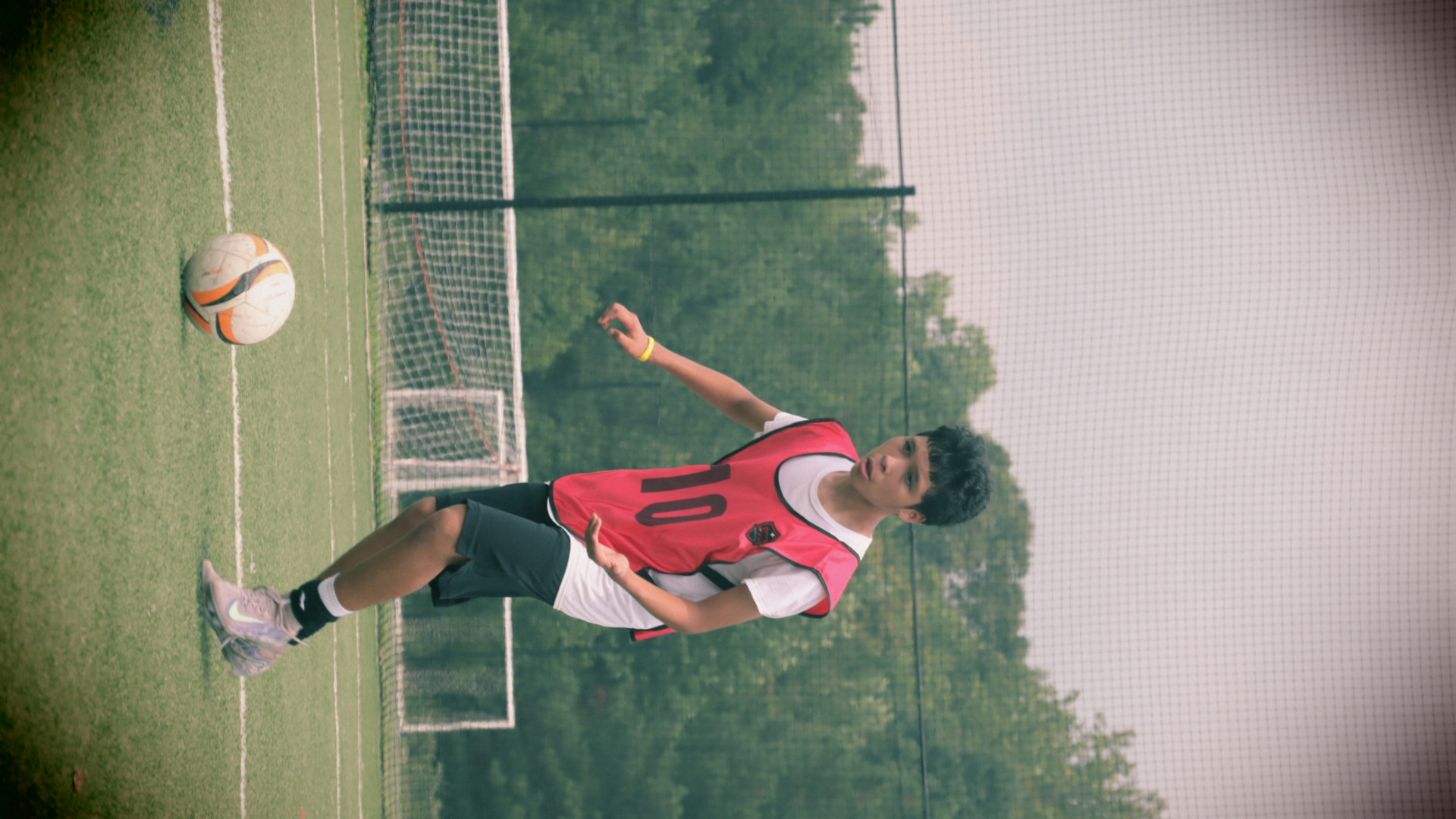 NC United FC tryout athlete driving the ball forward in a red bib