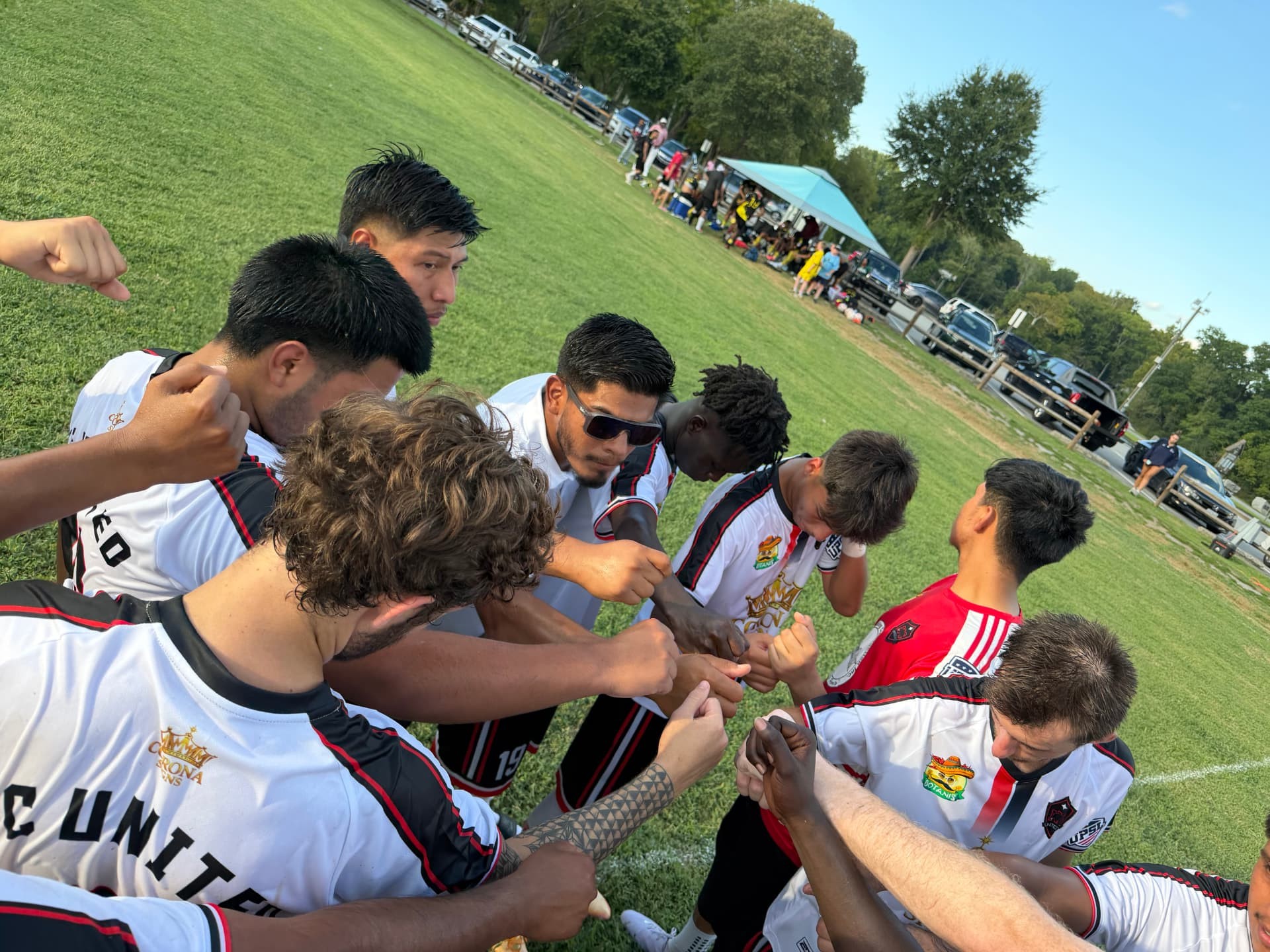 NC United FC players and staff bringing their hands together before competition.