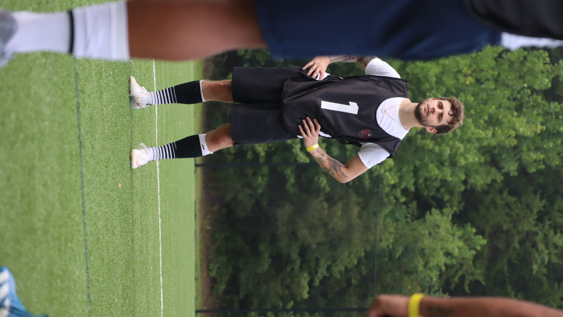 Player in a black bib awaiting the next tryout drill