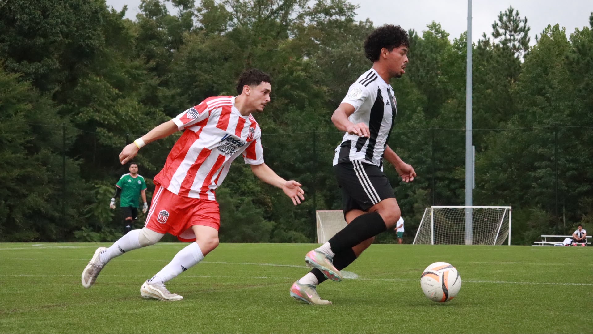 NC United FC player carrying the ball forward as a Gastonia City FC opponent gives chase during the August 22 preseason friendly