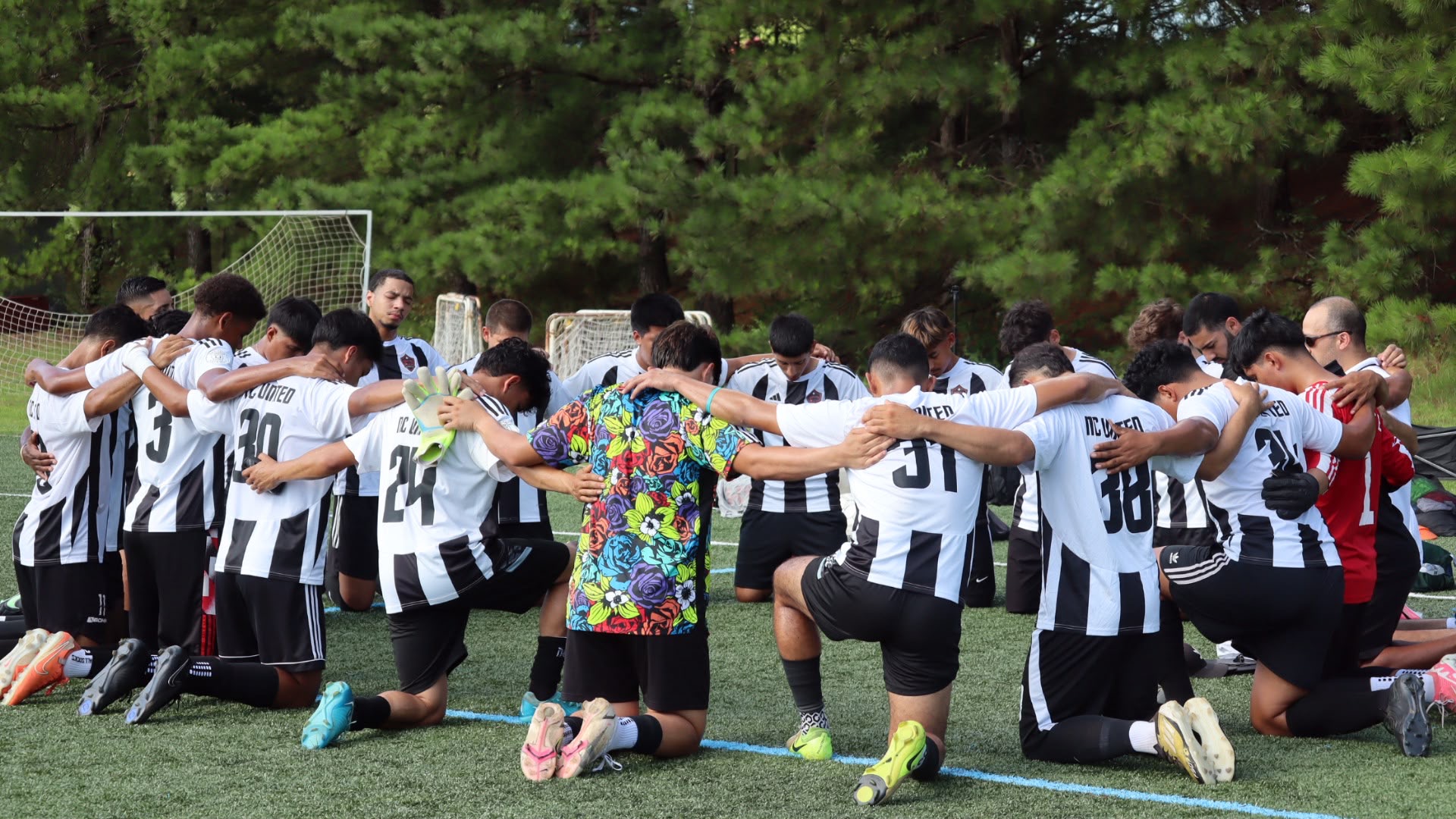 NC United FC players gathered together in prayer before a match