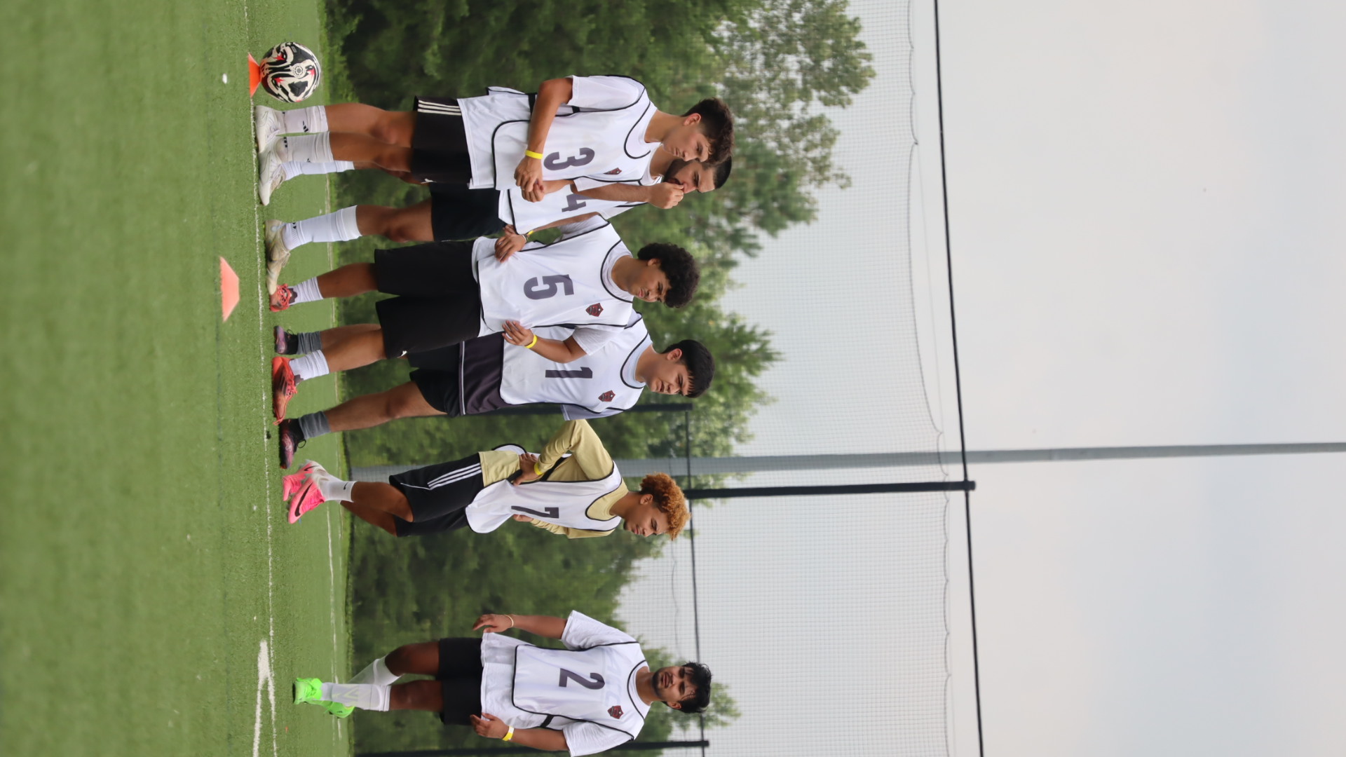 Group of NC United FC tryout participants listening to coaching instructions