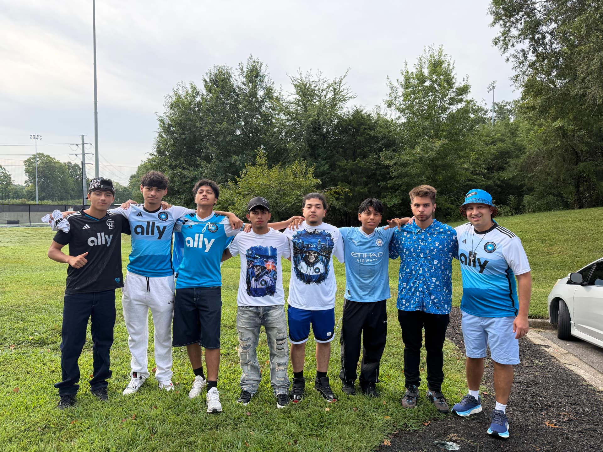 Members of the NC United FC family standing arm in arm before boarding the supporters buses from Charlotte to Atlanta
