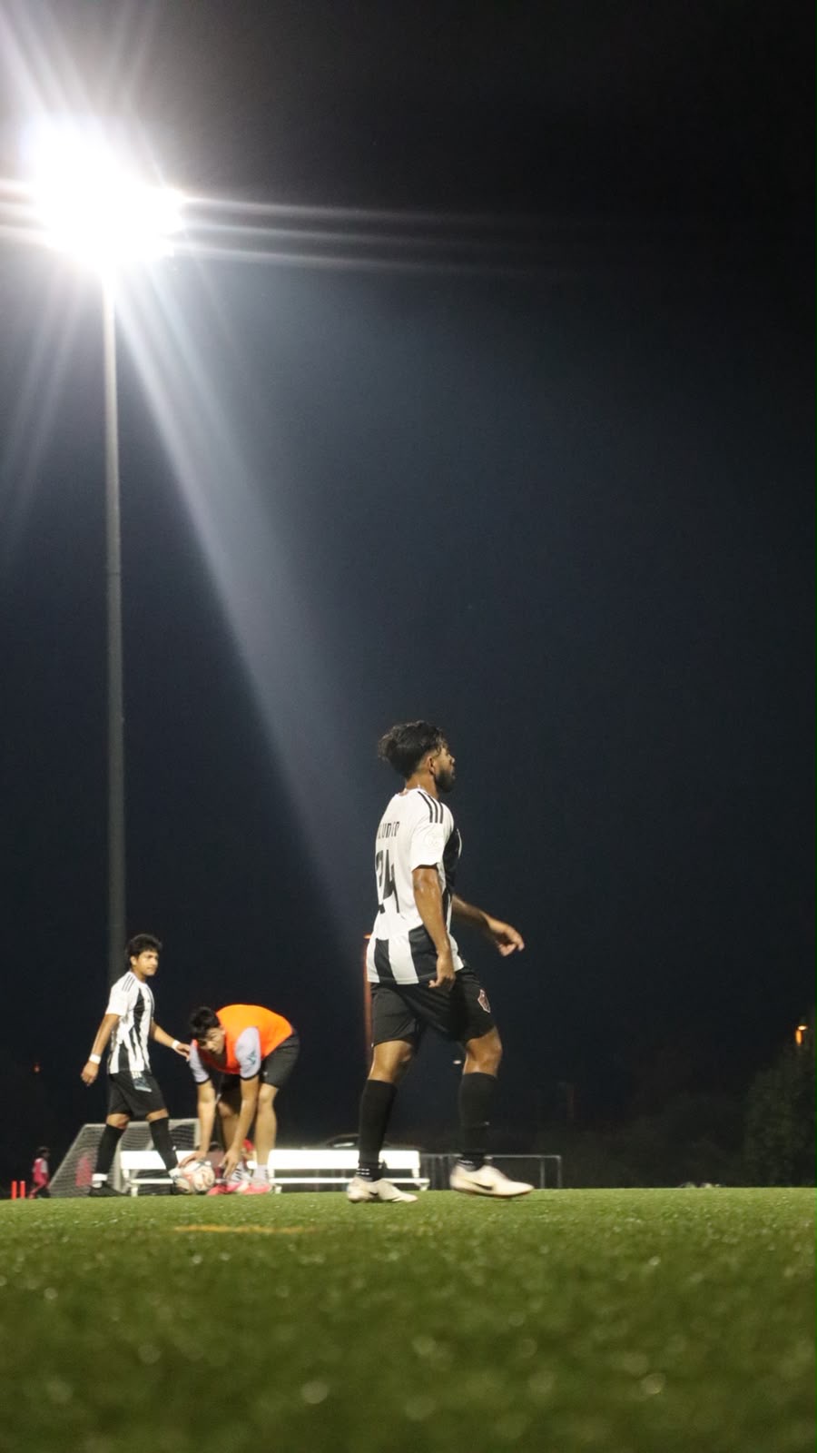NC United FC players warming up under the floodlights after nightfall