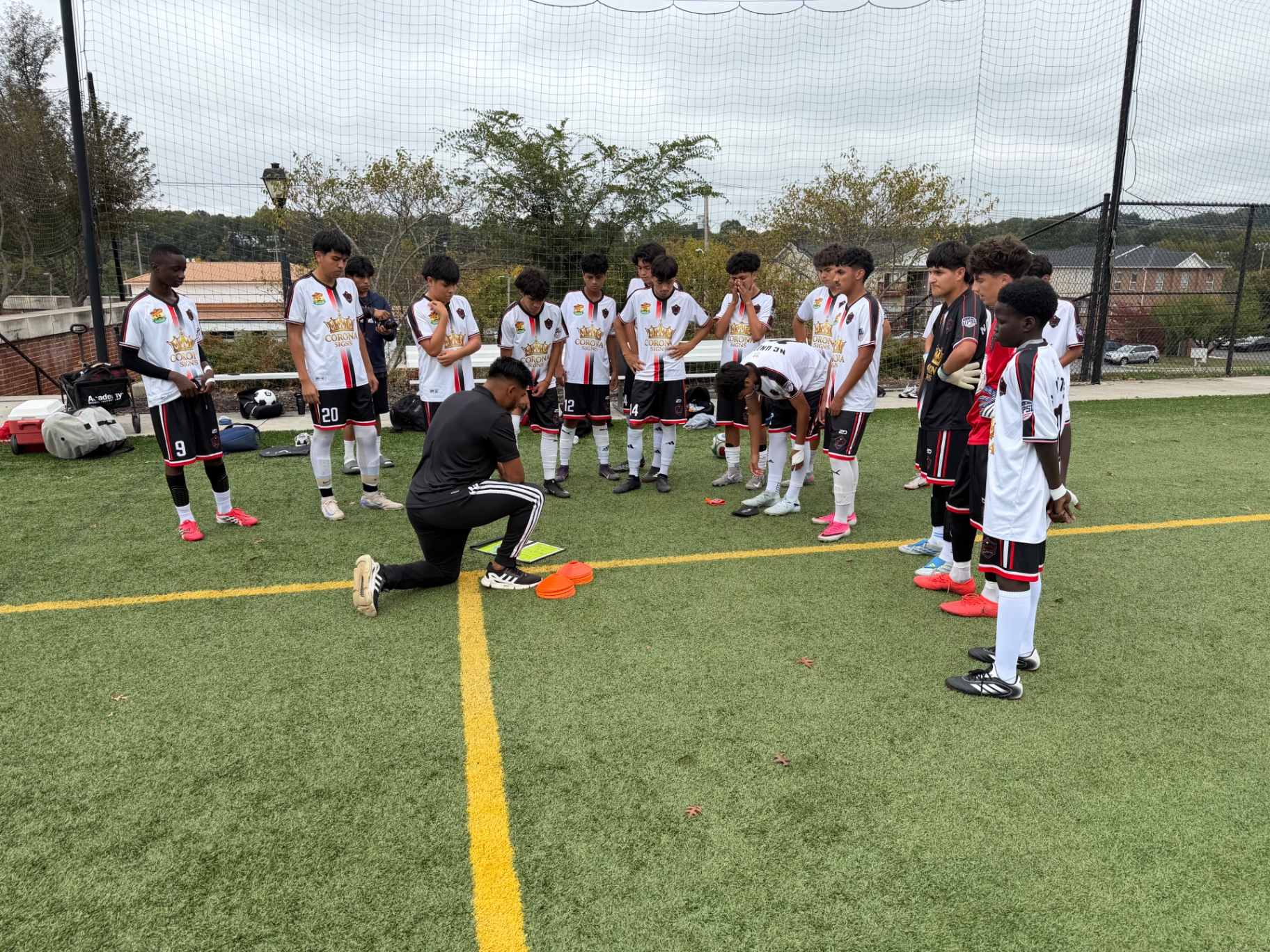 An NC United FC coach addressing the U17 Academy players gathered in a circle at the October 4 match in Radford, Virginia.